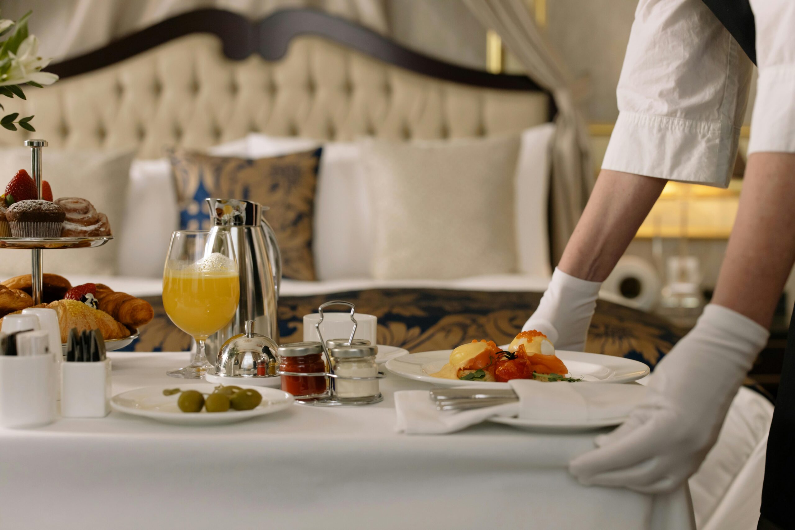 Elegant room service breakfast with orange juice and pastries in a hotel room.